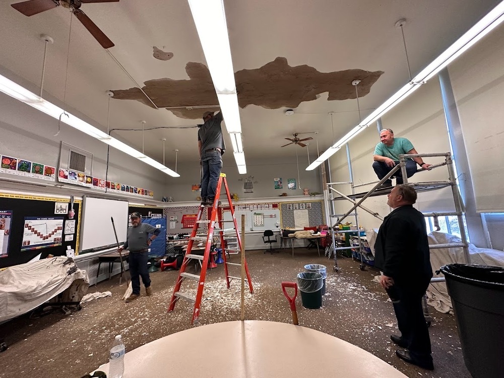Maintenance and custodial staff remove debris from water damage at Washington Elementary School